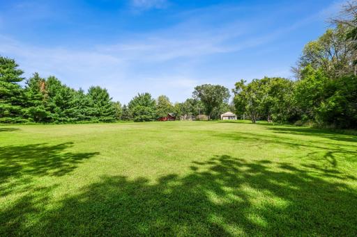 Scenic perspective showcasing the depth of the property, surrounded by mature trees and green space.