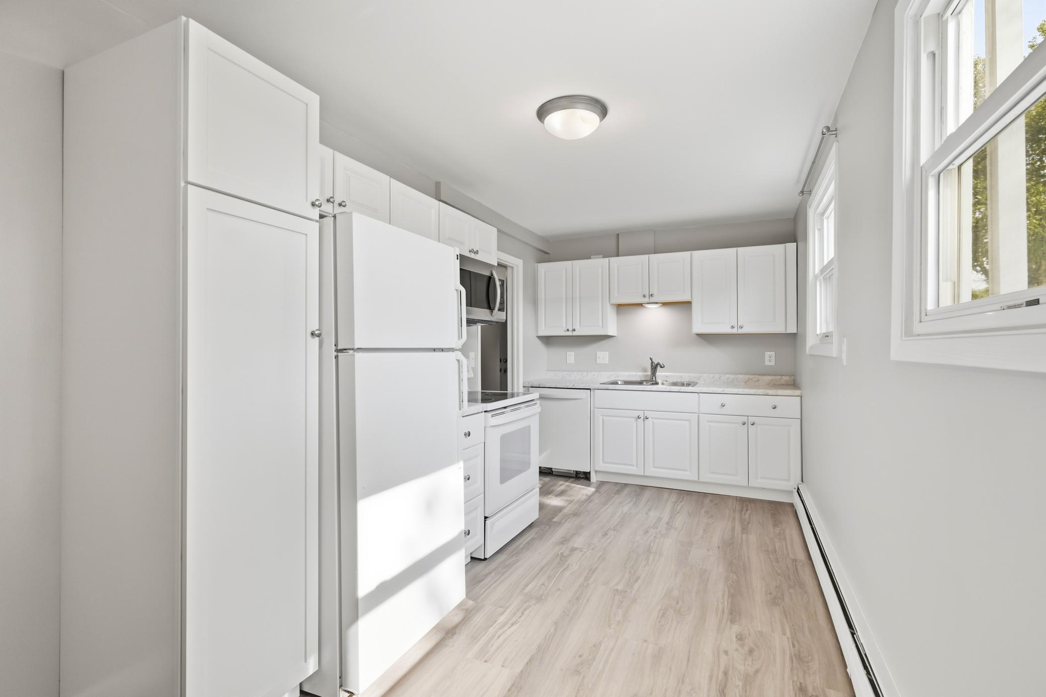 Recently updated lower-level kitchen featuring stylish new cabinets, durable laminate flooring, and a fresh, modern look.