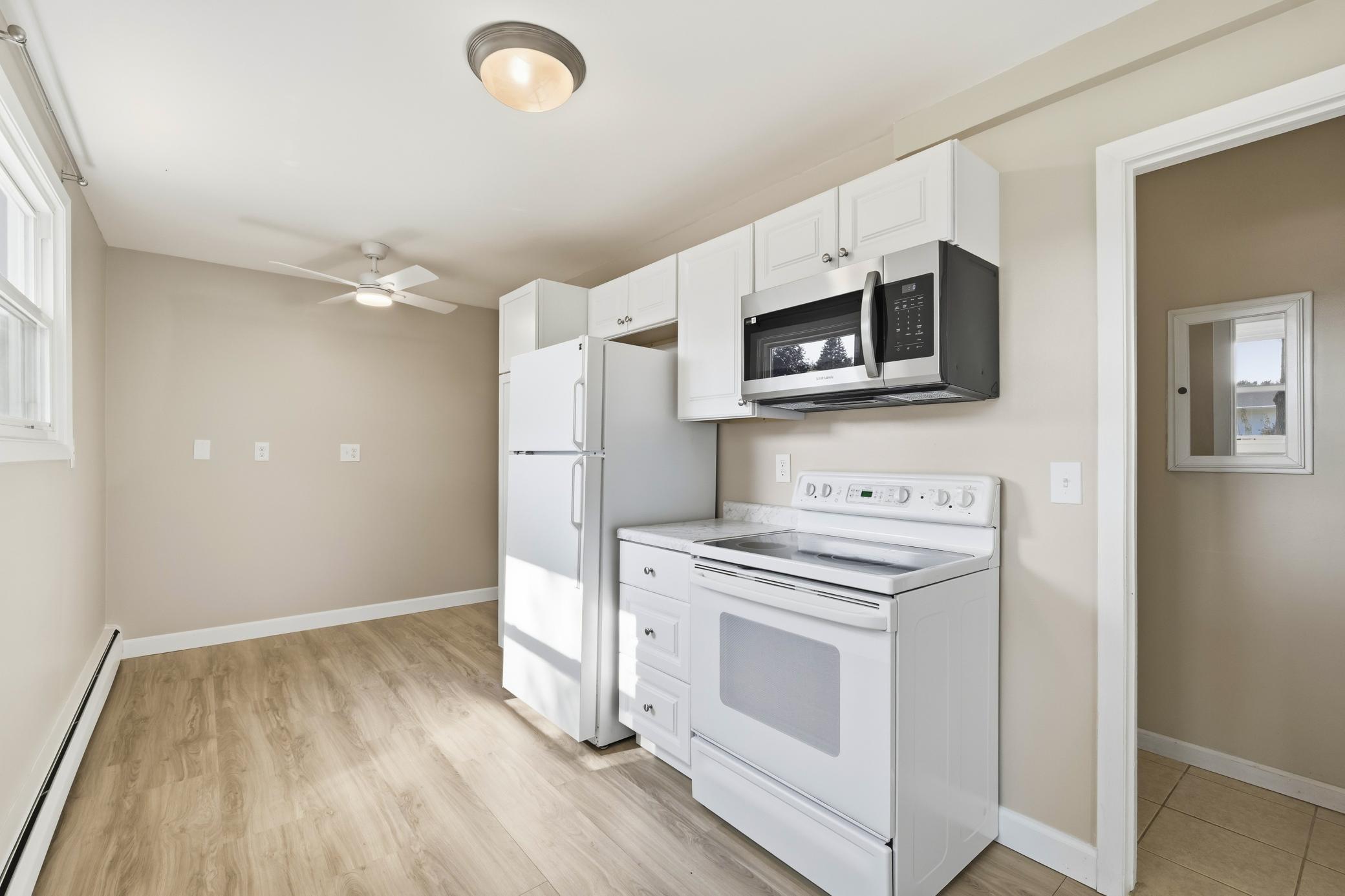 Eat-in lower-level kitchen with lookout windows that fill the space with natural daylight, creating a bright and inviting dining area.