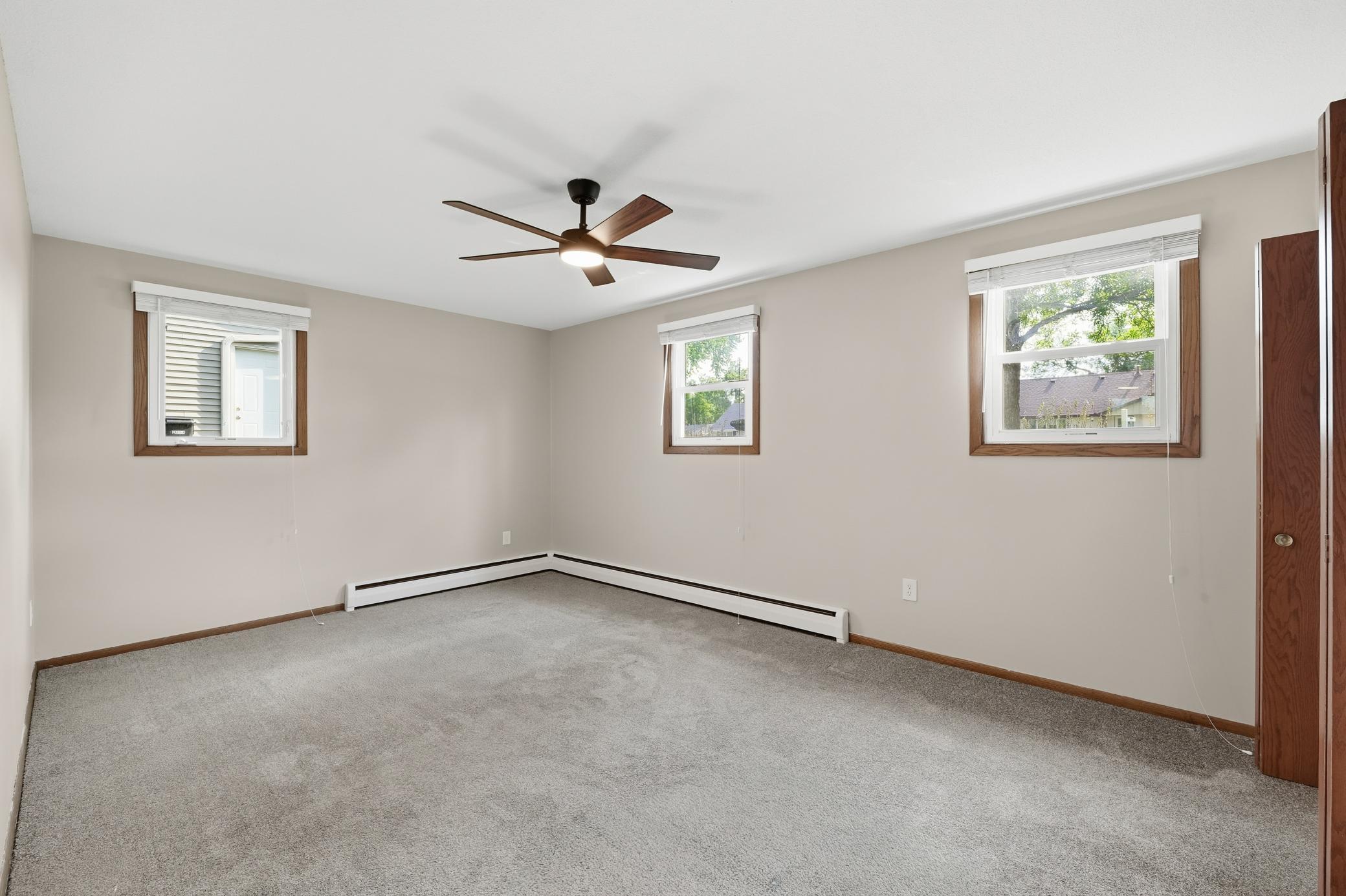 Lower-level bedroom featuring ample closet space and windows on two sides of the room, providing great natural light and a comfortable, airy feel.