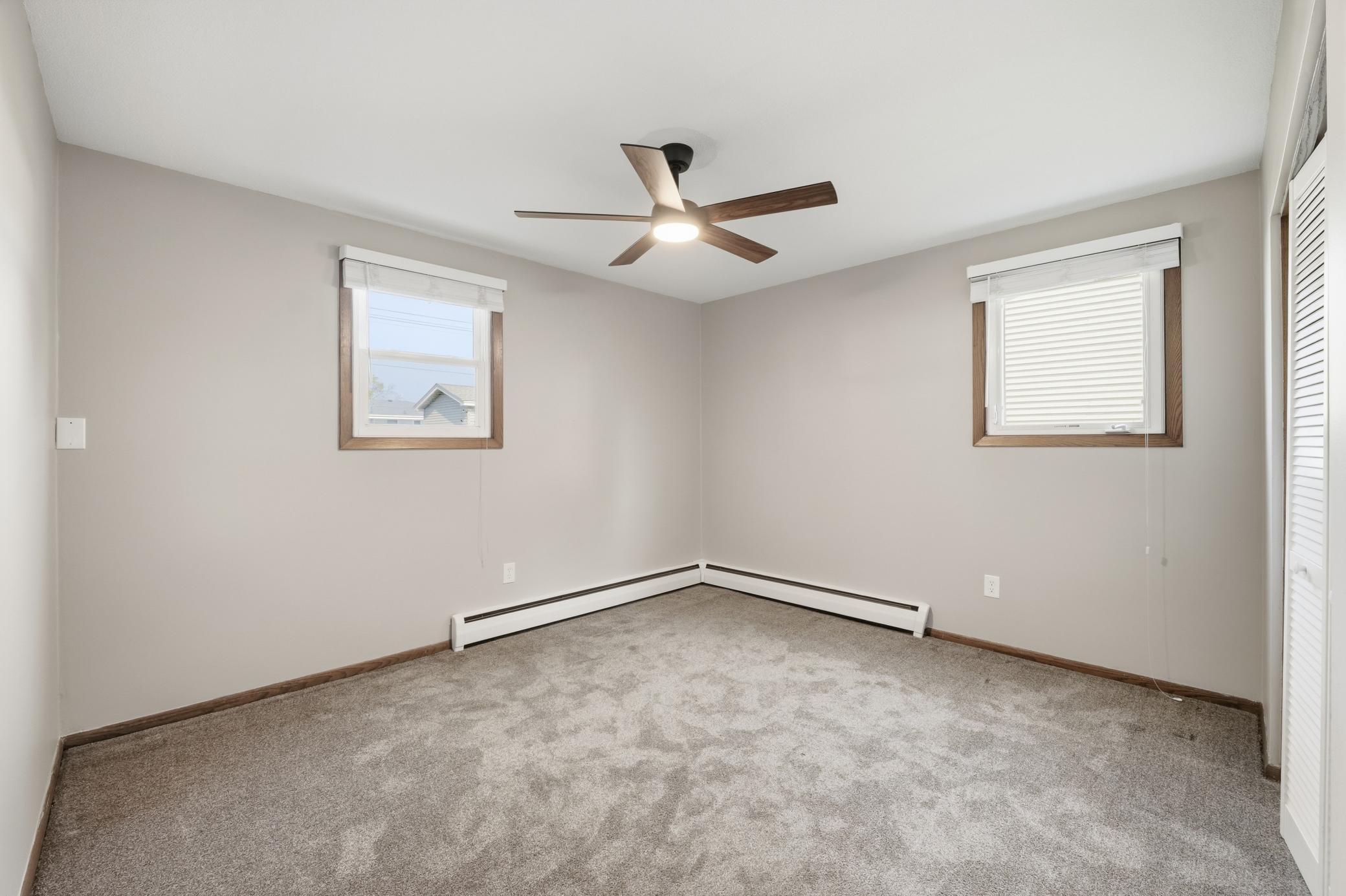 Second lower-level bedroom featuring windows on both sides of the room, allowing for abundant natural light and a bright, comfortable living space.