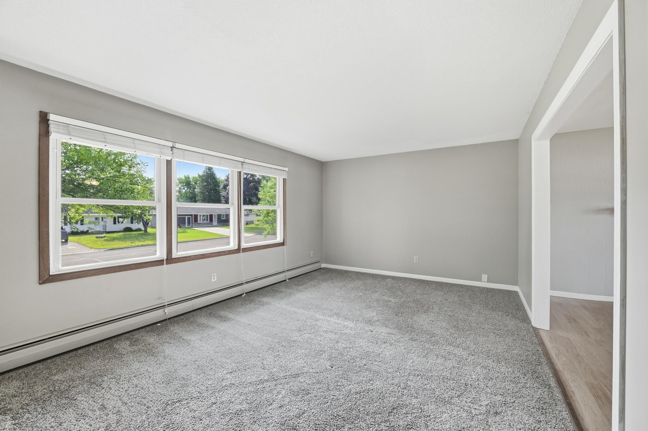 Main-level family room featuring large windows overlooking Main Street, filling the space with abundant natural light and creating a bright, welcoming atmosphere.