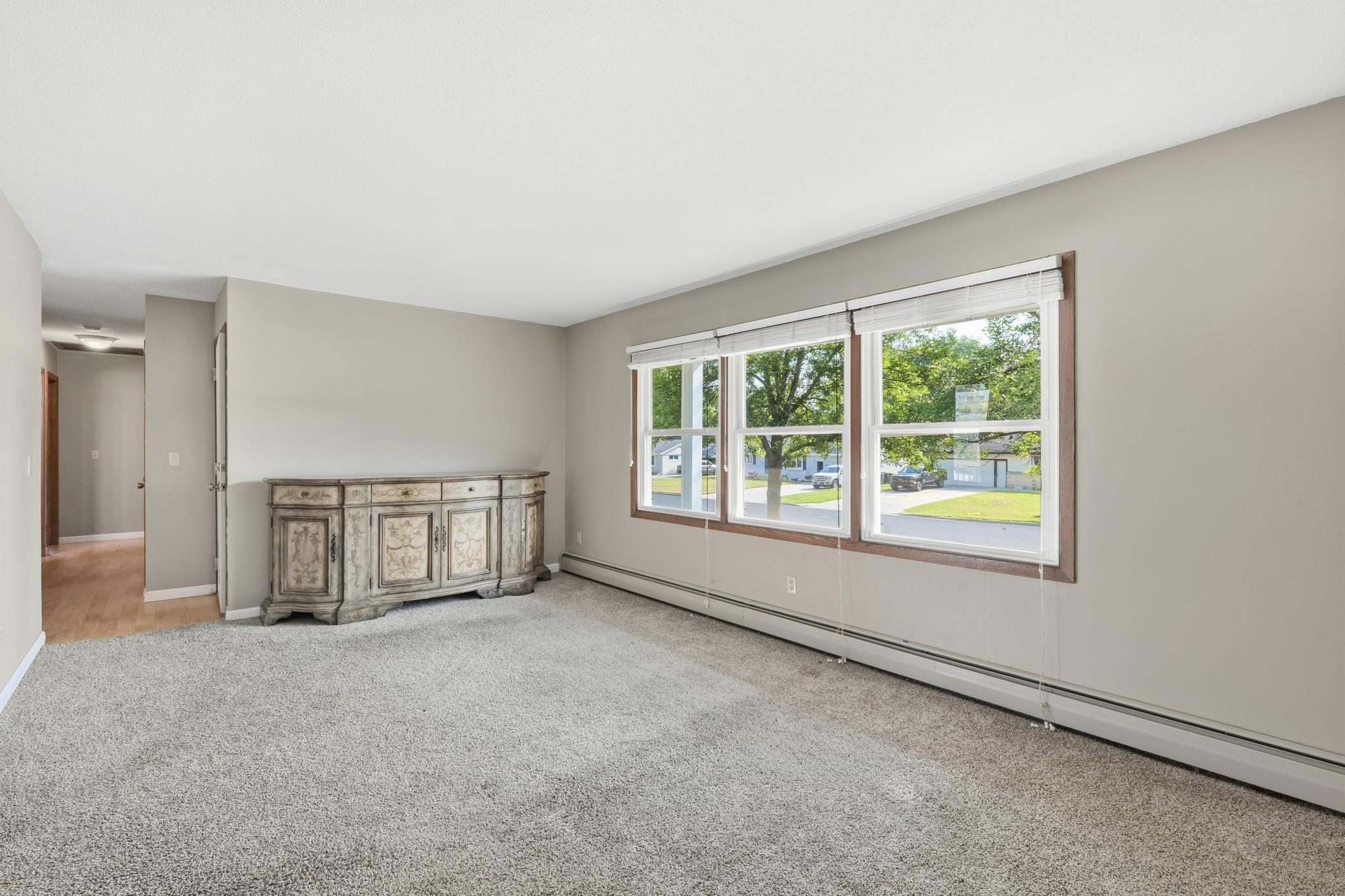 Main-level family room featuring large windows overlooking Main Street, filling the space with abundant natural light and creating a bright, welcoming atmosphere.