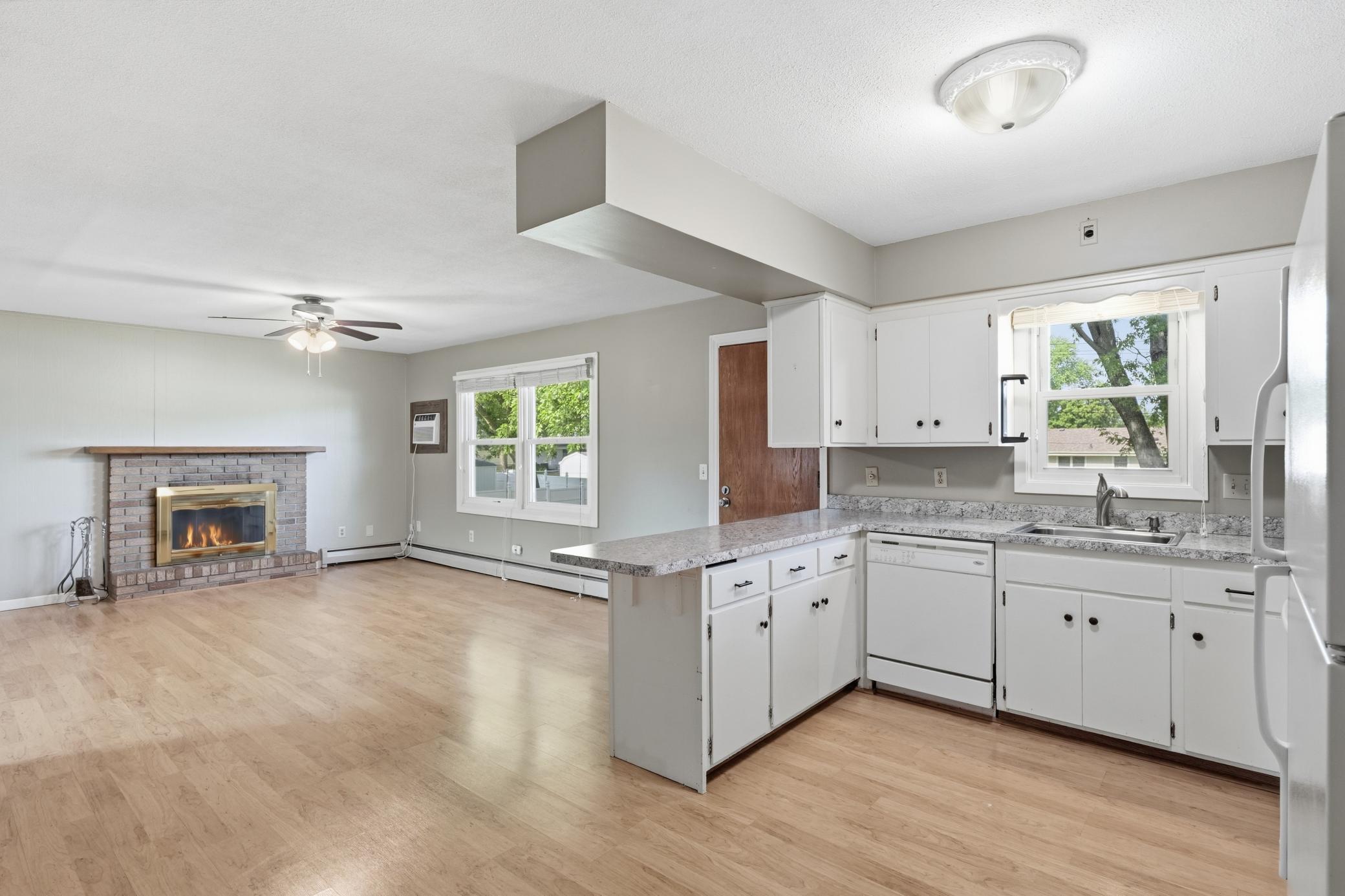 Open-concept kitchen featuring a functional island, durable laminate flooring throughout the kitchen and living area, and a seamless layout perfect for everyday living and entertaining.