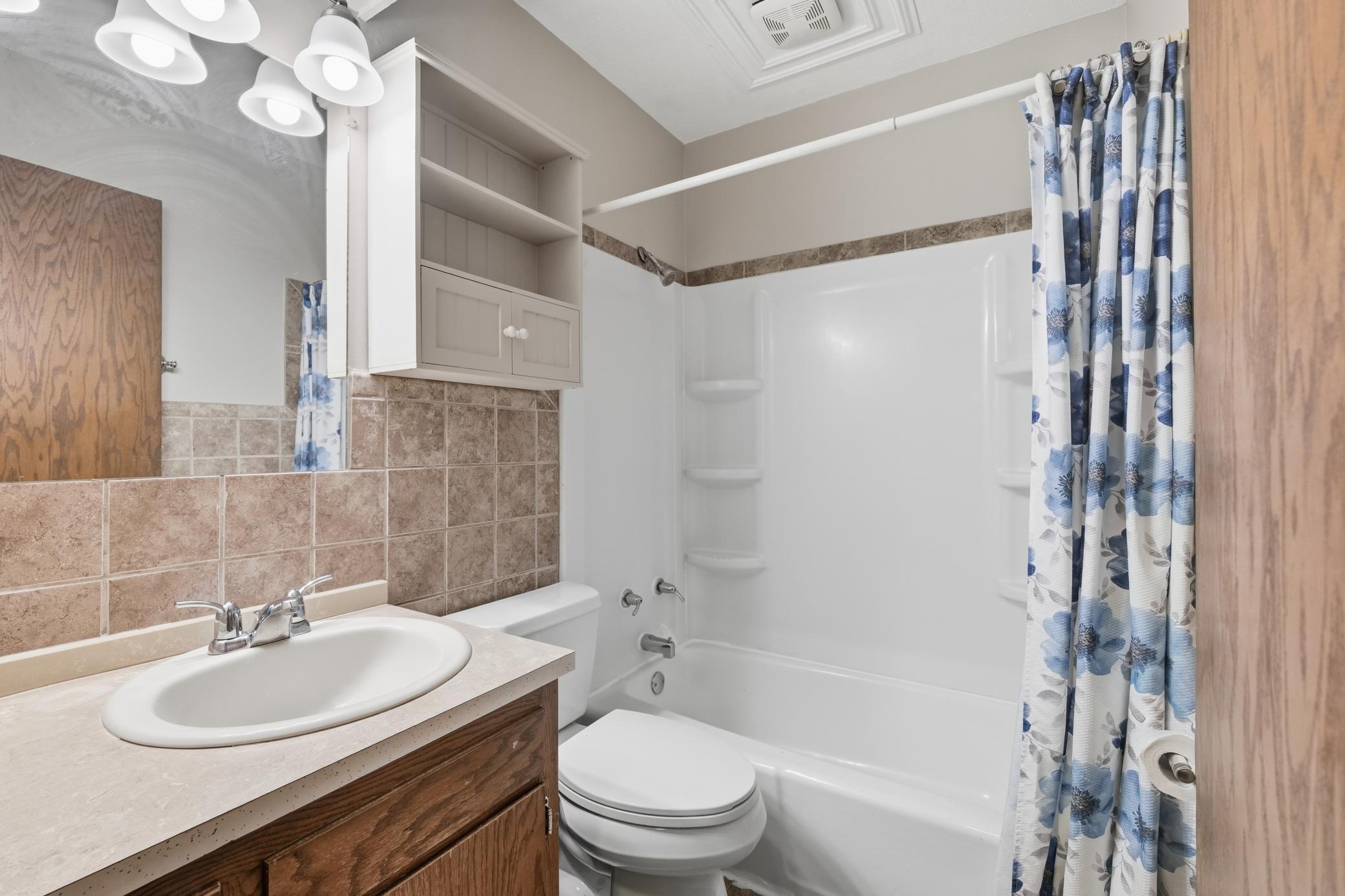Main-level bathroom featuring a convenient tub and a clean, functional design.