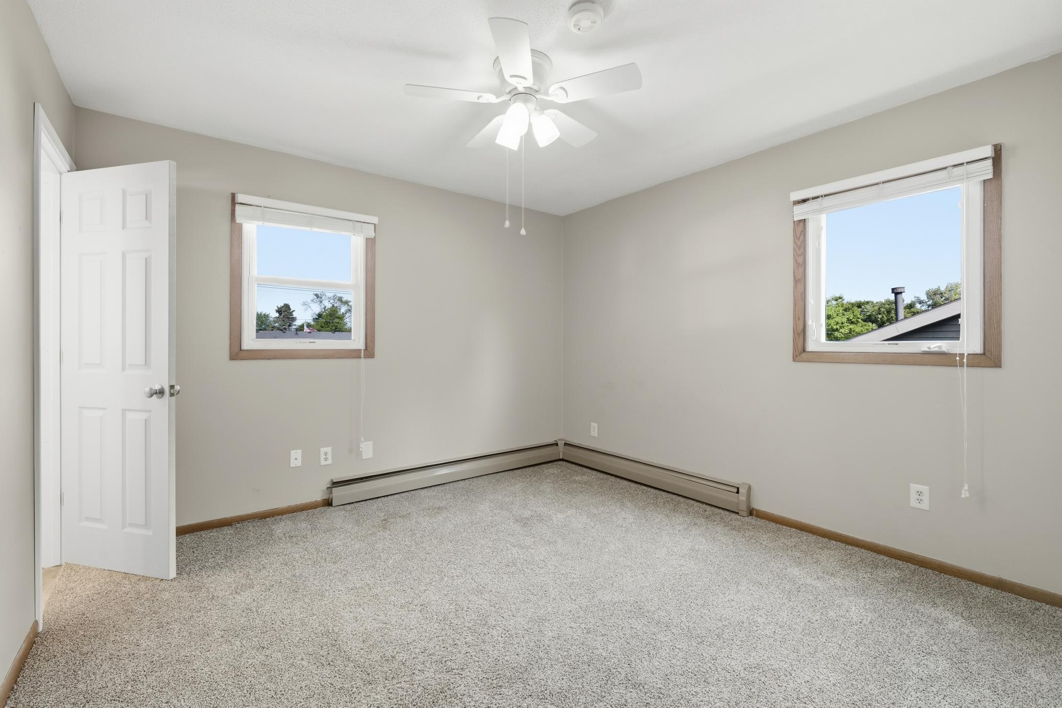 Main-level second bedroom featuring windows on both sides, bringing in abundant natural light and a bright, comfortable atmosphere.