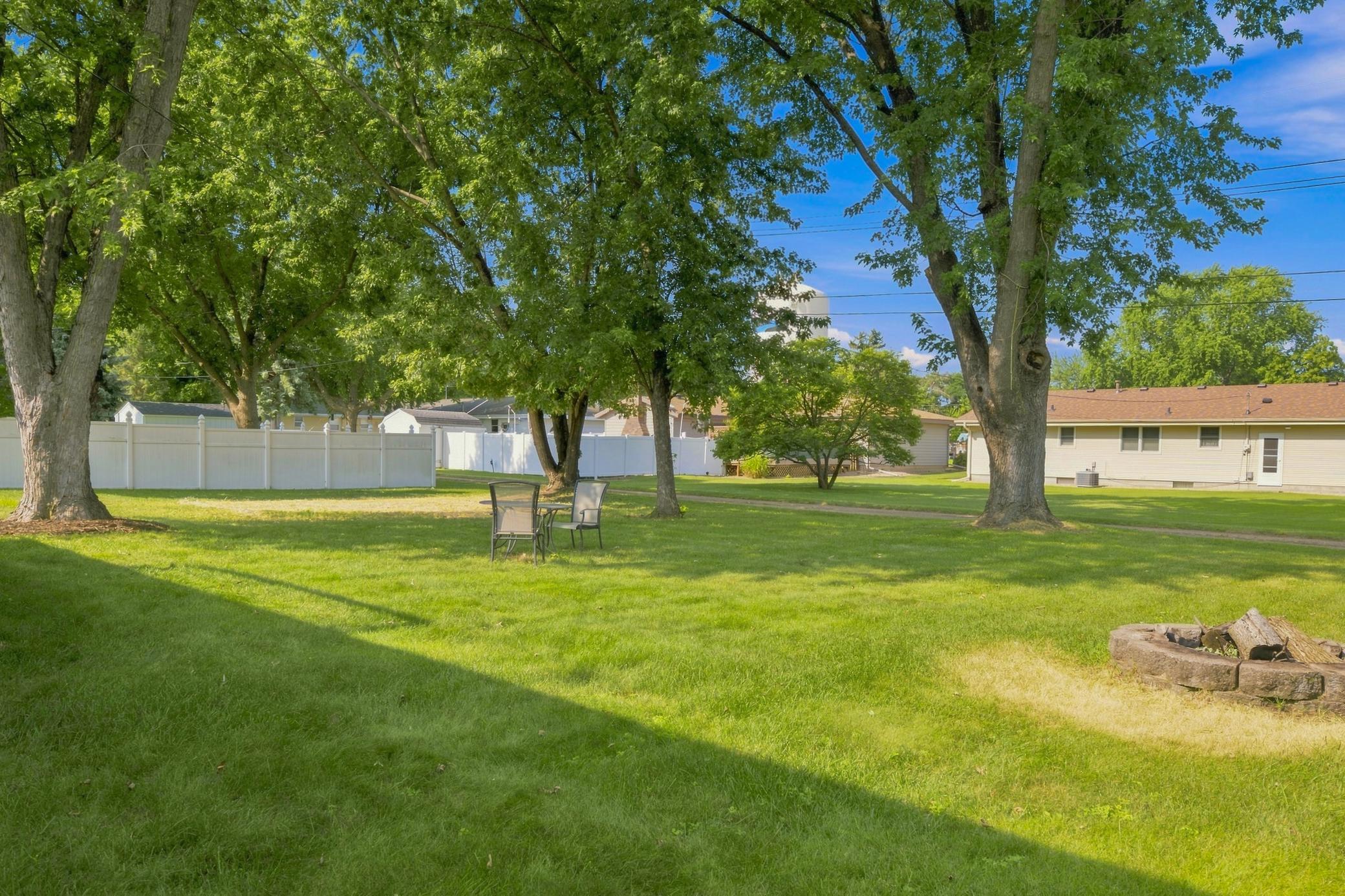 Spacious backyard featuring alley access and mature trees, offering privacy, shade, and outdoor enjoyment.