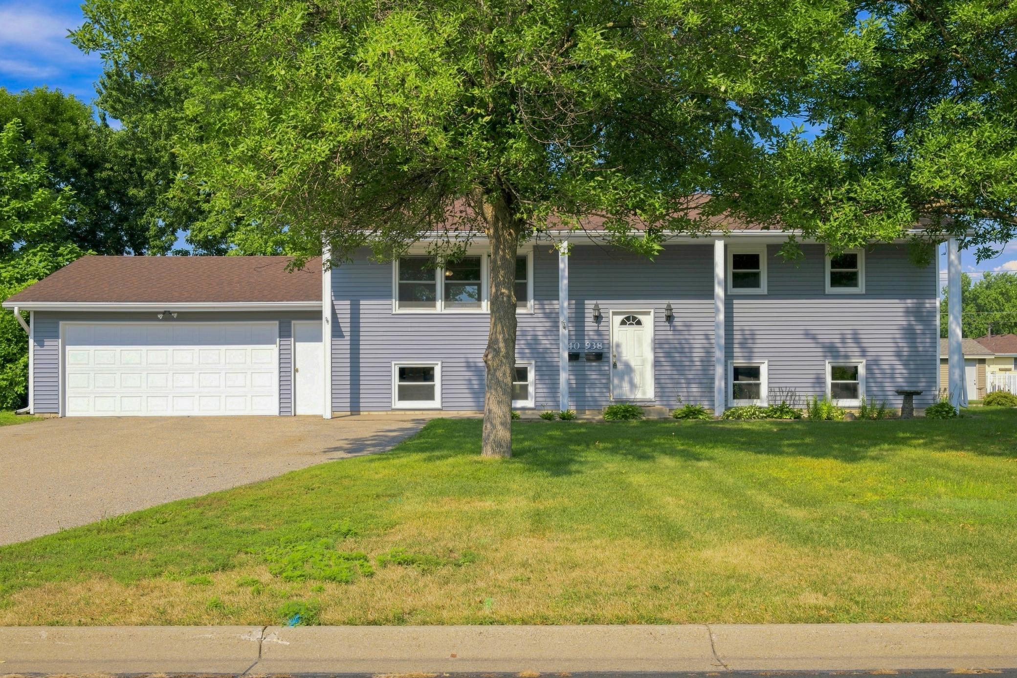 Welcoming front patio overlooking a spacious front yard, beautifully enhanced by a mature tree that adds shade and timeless curb appeal.