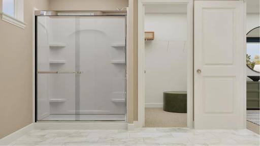 (Rendering, actual home's finishes will vary.) The en-suite bathroom features a glass-enclosed shower with convenient shelves to store bathing essentials