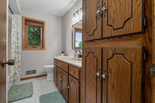 Bathroom tiled flooring, abundance of cabinetry and linen storage. Fresh paint, some updated fixtures, lighting, and bathroom mirrors.