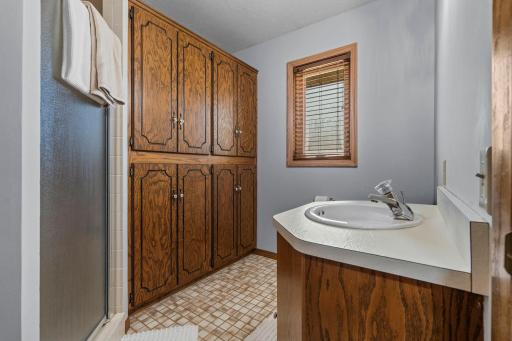 Main level 3/4 bathroom offers a ton of linen storage and walk in tiled shower. (Mirror currently missing in picture but installed and brand new)