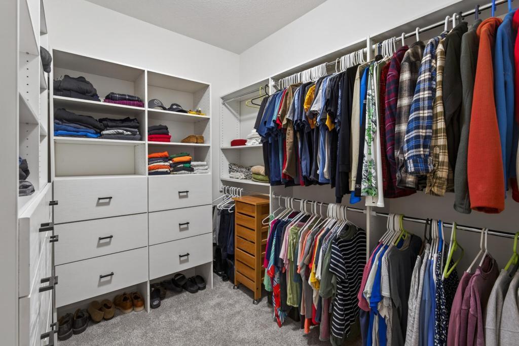 Primary walk-in closet with a laminate primary closet system with 13 drawers with ball-bearing slides.