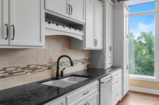 Granite countertops and modern tiled backsplash. Modern white cabinetry and Stainless Steel appliances.
