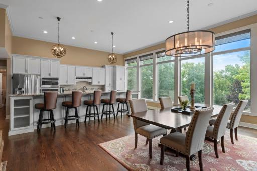 Beautiful hardwood flooring flows throughout the main-level living, dining, and kitchen areas, complemented by walls of windows that fill the home with natural light and frame stunning lake views.