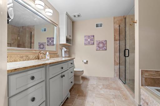 Granite countertops, oversized vanity with a ton of storage and beautiful tile and stone work.
