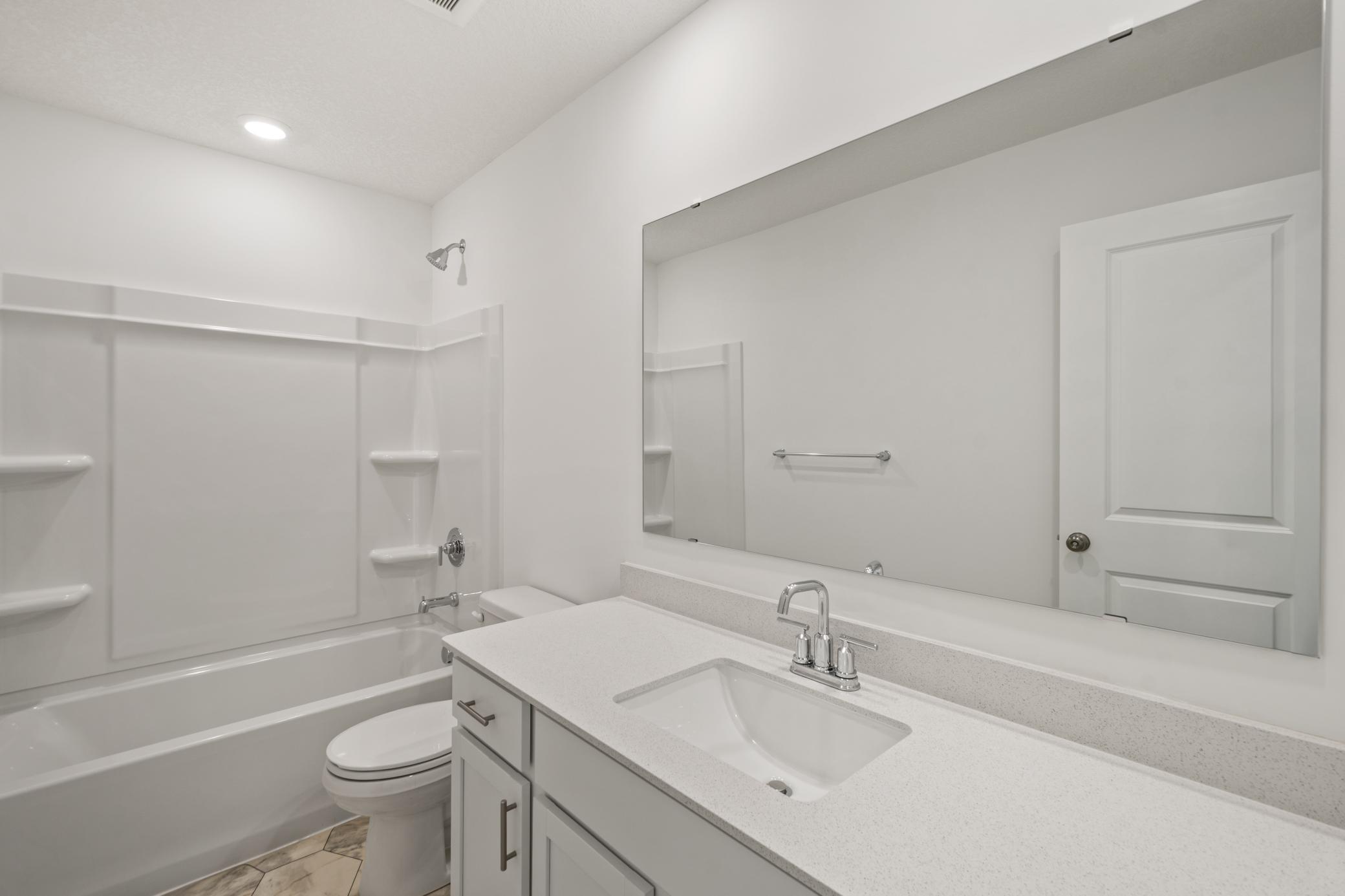 (Photo of an inventory home, actual homes finishes will vary) The Richmond's upper level secondary bathroom features a full bathroom and large vanity.