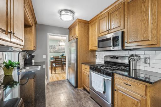 Updated kitchen featuring granite countertops, tile backsplash, and new flooring.jpg