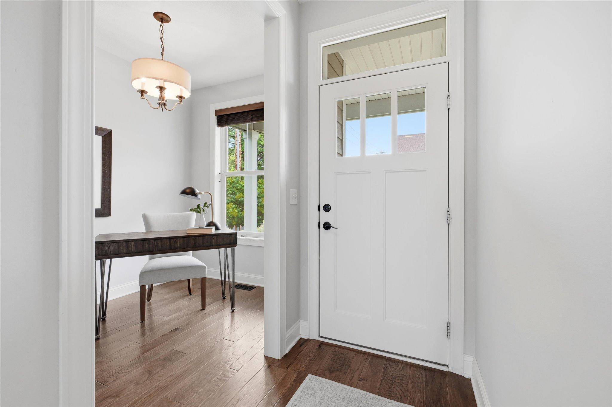 Bright, inviting foyer features durable hardwood flooring, abundant natural light, and an open sightline into the home, creating a warm first impression.