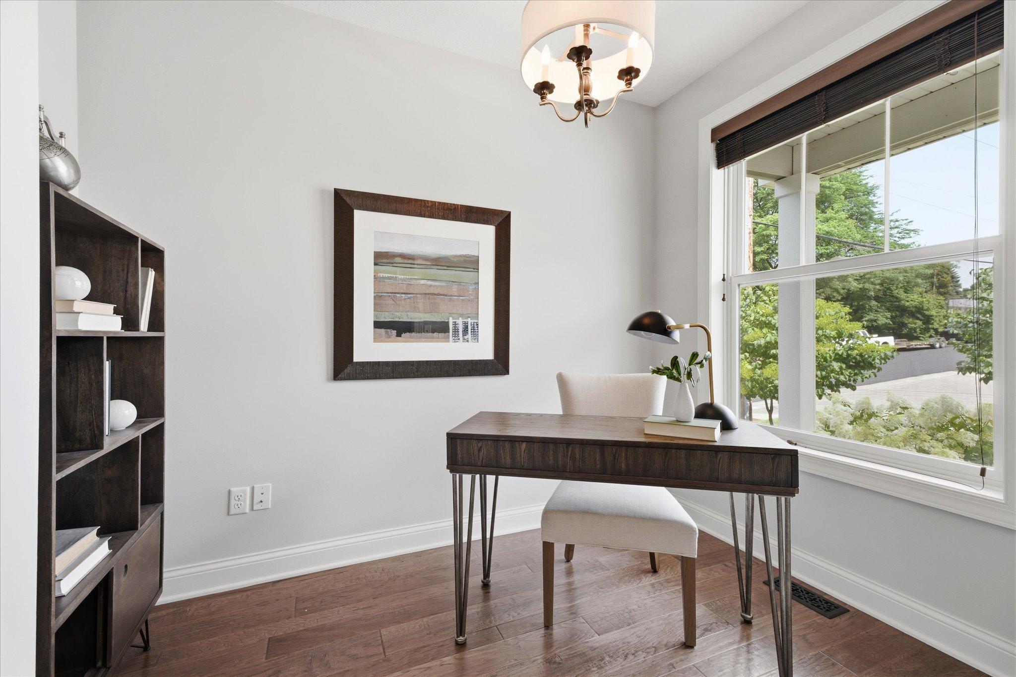 Dedicated main-level office offers a quiet, sun-filled workspace with a large picture window, making it ideal for working from home, studying, or a flex room.