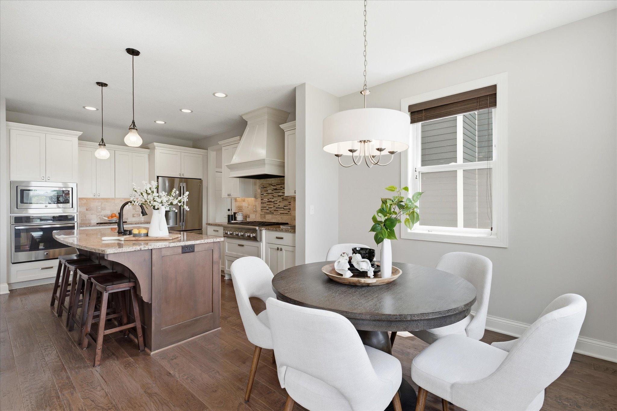 Sunny informal dining area is perfectly positioned adjacent to the kitchen and offers easy access to the maintenance-free deck for effortless indoor-outdoor entertaining.
