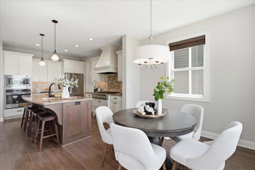 Sunny informal dining area is perfectly positioned adjacent to the kitchen and offers easy access to the maintenance-free deck for effortless indoor-outdoor entertaining.