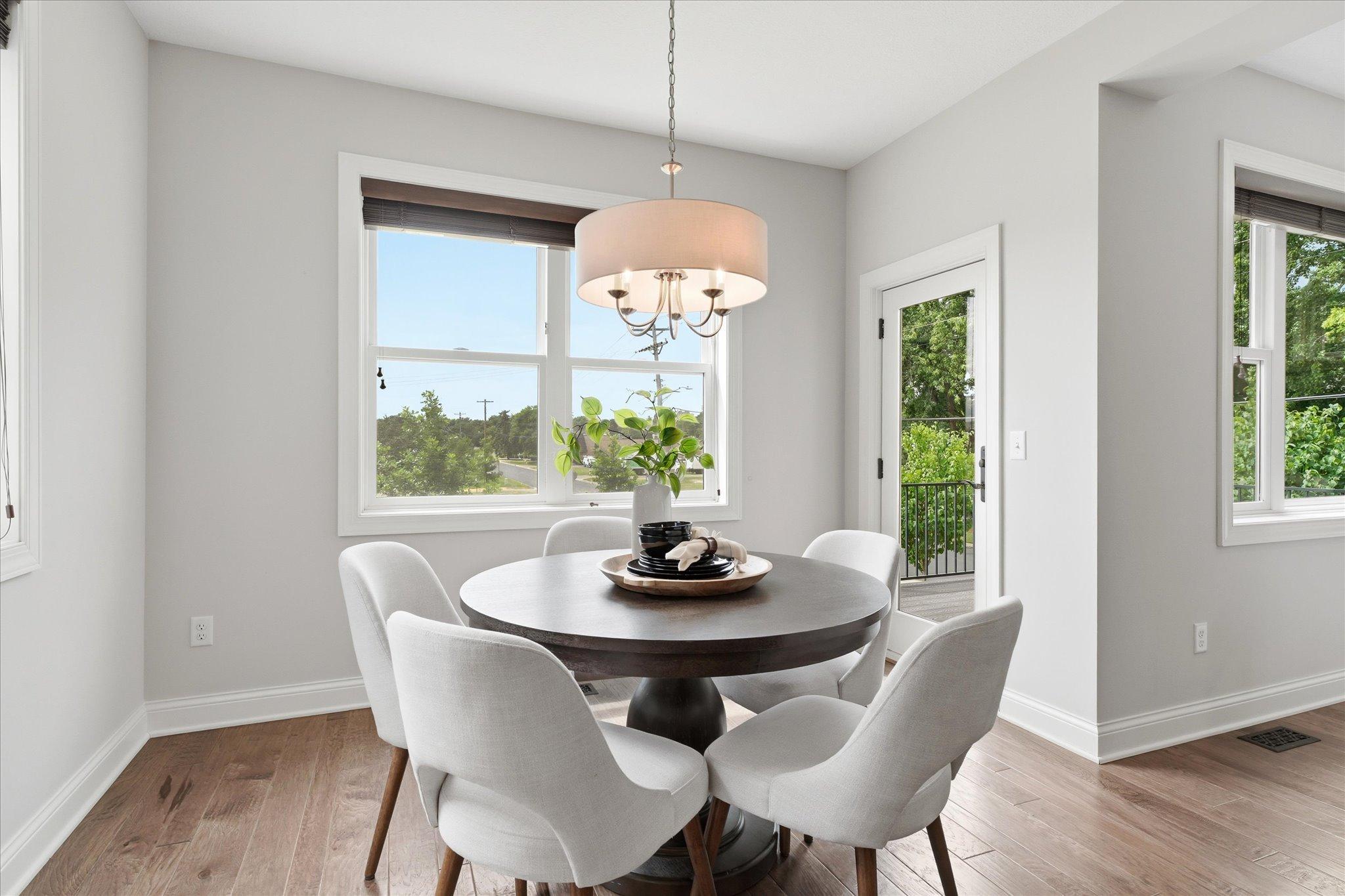 Bright dining space is surrounded by large windows that fill the room with natural light and create an inviting setting for everyday meals.
