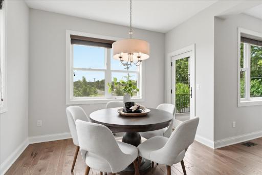 Bright dining space is surrounded by large windows that fill the room with natural light and create an inviting setting for everyday meals.