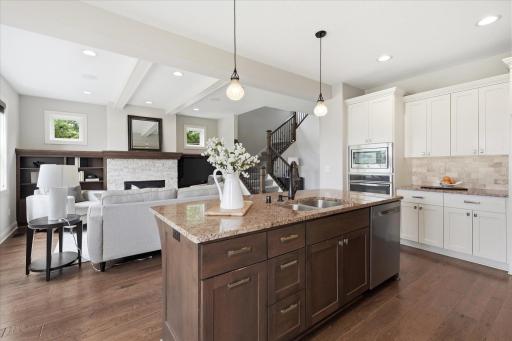 Expansive center island with granite countertops, undermount sink, abundant storage, and seating makes this kitchen the true heart of the home.