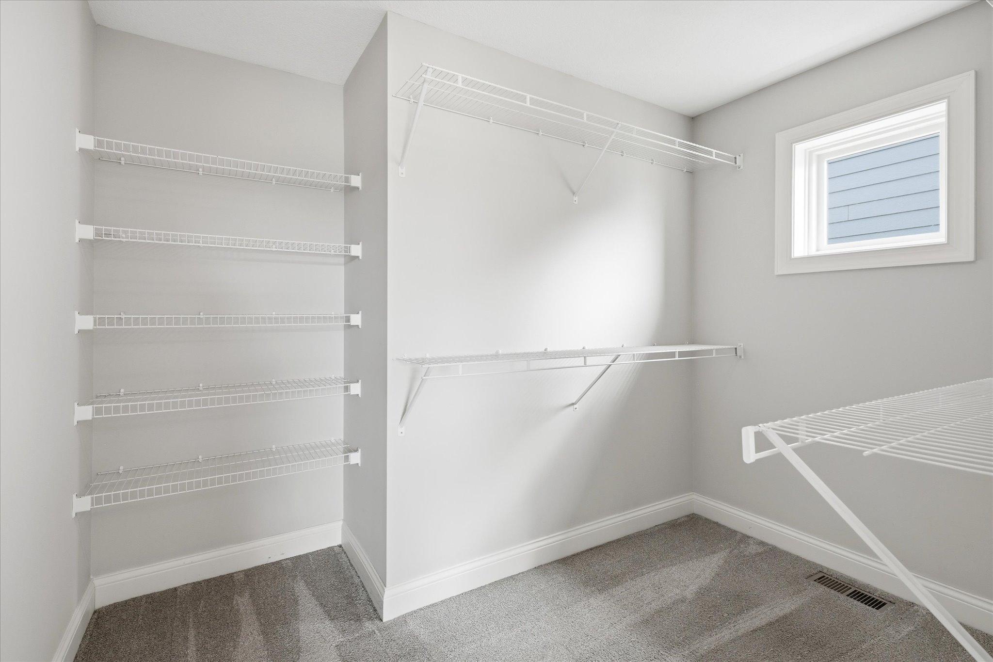 Massive walk-in closet provides exceptional storage with extensive shelving and hanging space to accommodate every wardrobe.