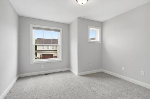 Spacious secondary bedroom offers plush carpeting, abundant natural light, and a generous layout.