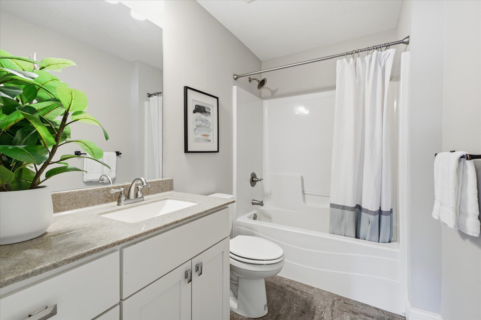 Full upper-level bath features a large vanity with storage, durable flooring, and a tub/shower combination to comfortably serve the secondary bedrooms.