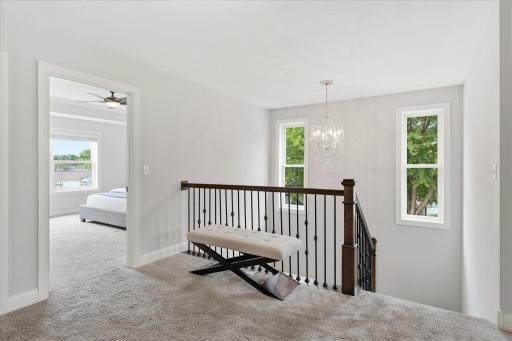Bright upper-level landing offers easy access to all four bedrooms, the laundry room, and full bath.