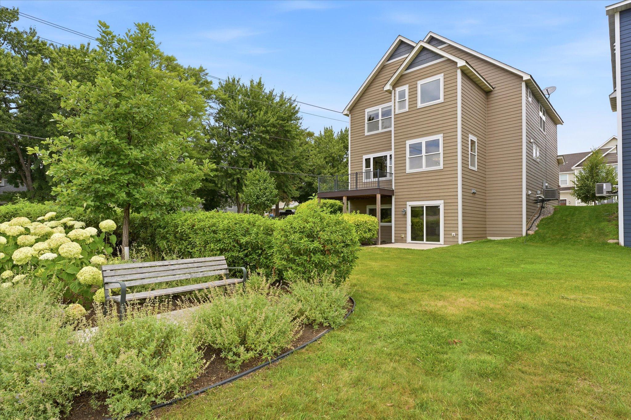 Enjoy a beautifully landscaped backyard with mature trees, lush green space, colorful perennial gardens, and plenty of room to relax or play.