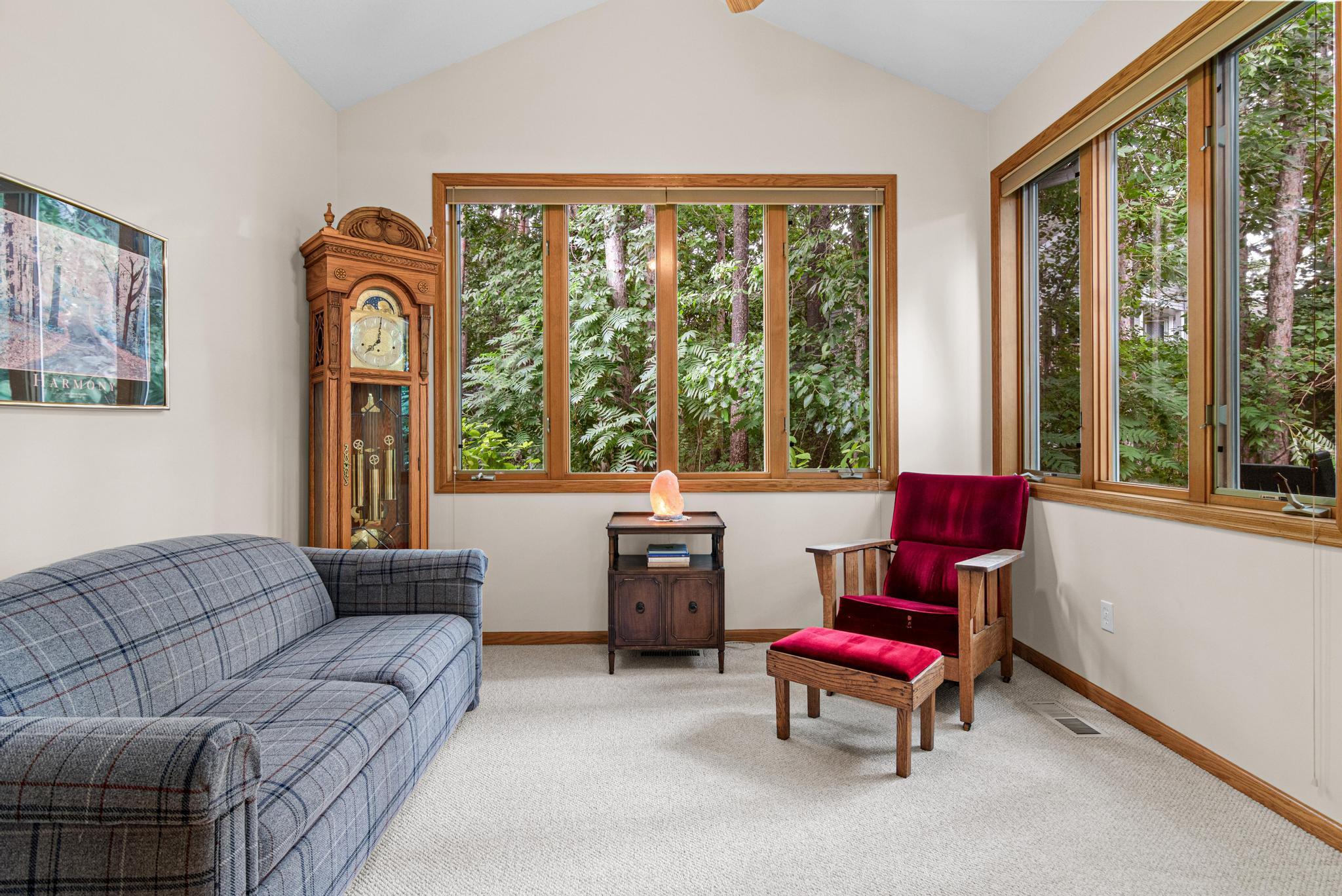 Enjoy the sunroom with large windows and lovely wooded views