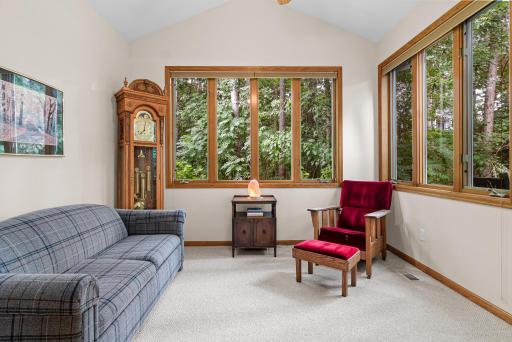 Enjoy the sunroom with large windows and lovely wooded views