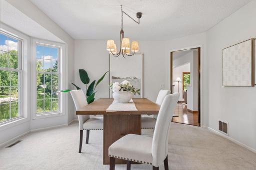 The formal dining room has a bay of windows with extended views of the pond.