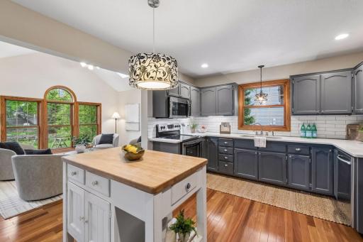 Gleaming hardwood floors lead into an updated kitchen with a butcher block center island.