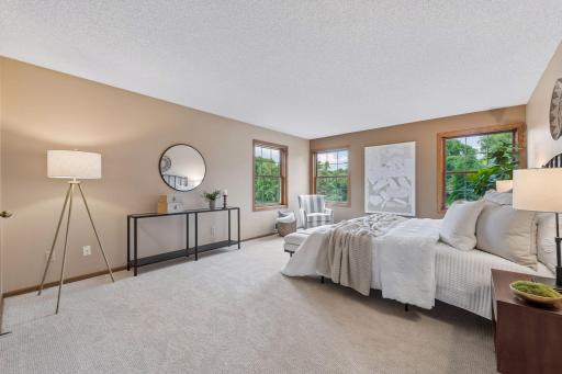 The spacious primary suite has a walk-in closet and tranquil views of the pond.