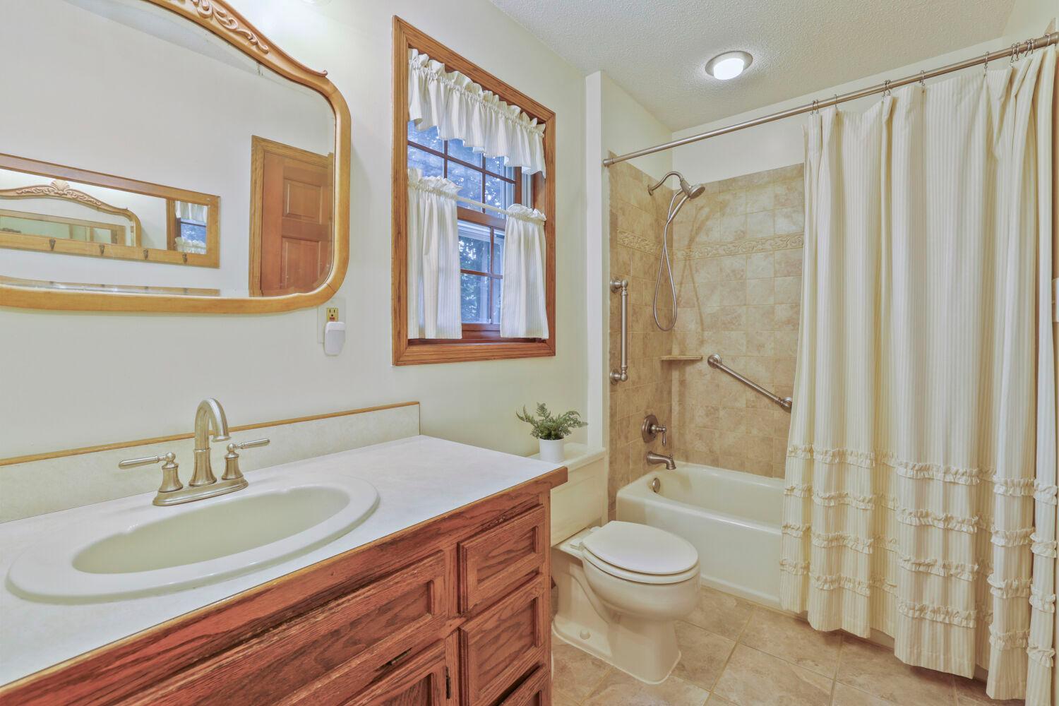 This bathroom includes a shower within the bathtub.