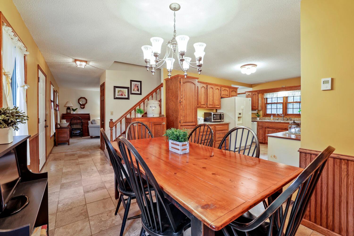 Wainscoating, travertine flooring ,and open stairs to the upper level.