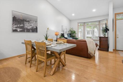 The vaulted ceiling and hardwood flooring continue into the dining area and living room.