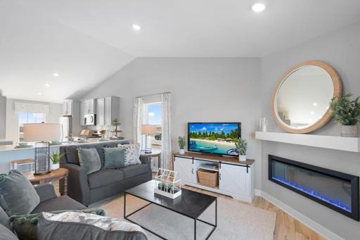 Open concept living with a modern electric fireplace. Our smart home package is included in every home. Photo is of actual home. Colors and options may vary. Ask Sales Agent for details.
