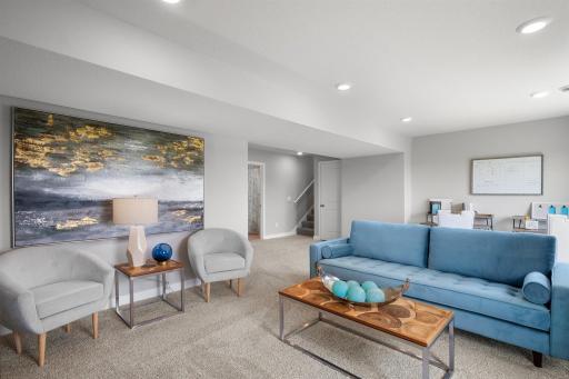 Once downstairs, the entire level flows from the focal point offered by this huge family room. Sure to become a family favorite hangout spot, the room is just steps from the lower level bedroom and bathroom! Photo is of similar home.