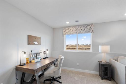 Once downstairs, the entire level flows from the focal point offered by this huge family room. Sure to become a family favorite hangout spot, the room is just steps from the lower level bedroom and bathroom! Photo is of actual home.