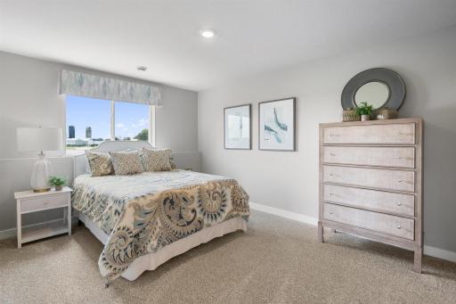 Tucked down in the lower level, and away from the hustle and bustle of the main level living spaces, this bedroom resides adjacent to a full bath and serves as the perfect guest room or your home office! Photo is of similar home.