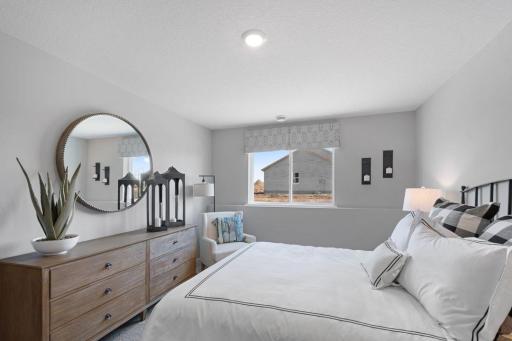 Tucked down in the lower level, and away from the hustle and bustle of the main level living spaces, this bedroom resides adjacent to a full bath and serves as the perfect guest room or your home office! Photo is of actual home.