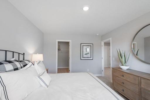 The lower level also includes this large bedroom, which has its own walk-in closet and immediate access to a full bathroom. Photo of actual home, colors and options will vary. Ask Sales Agent for details.