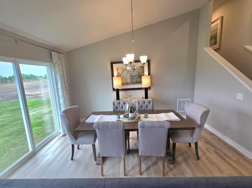 Bright light streams through the patio doors into the dining space. Photos of actual home. Colors and options may vary. Ask Sales Agent for details.