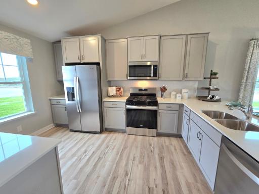 A true designer kitchen; Quartz countertops complimented by tile backsplash, a massive peninsula, plenty of cabinet space, plus a cabinet pantry! Photo is of actual home. Options and colors may vary. Ask Sales Agent for details.