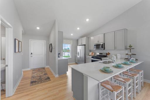 A true designer kitchen; Quartz countertops complimented by tile backsplash, a massive peninsula, plenty of cabinet space, plus a pantry cabinet! Photo is of model home. Options and colors may vary. Ask Sales Agent for details.